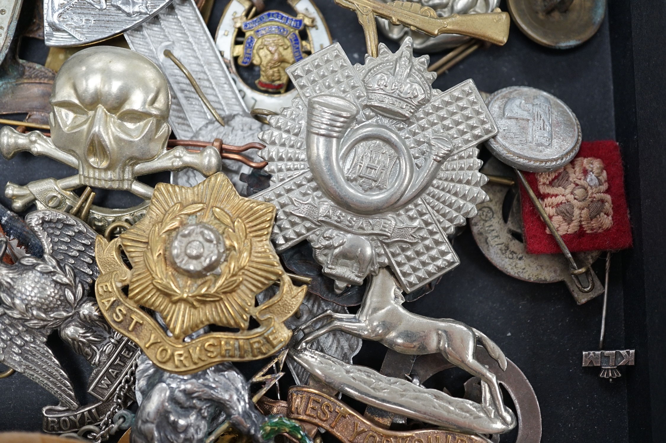 A collection of military cap badges and medals, including a First World War medal pair awarded to A.M. F.W. Wright, together with seventeen British and German cap badges including; the West Yorkshire Regiment, the Royal